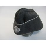 A Third Reich style grey wool M38 cap, bearing white metal  WWII National Air Raid Protection League