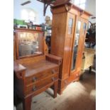 An Arts and Crafts style wardrobe, the mirror door flanked by two panels with stained glass inserts,