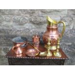 A collection of copper and brass to include a large jug, pair of candle sticks, a ladle, dish,