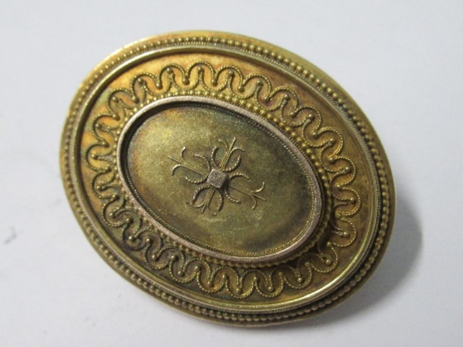 A Victorian oval brooch, unmarked, with locket back, 3.9cm long, 11g gross