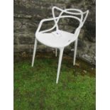 A white Kartell Masters armchair