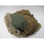 A Third Reich style winter hat, of green wool, with olive green quilted lining, having fur lined ear