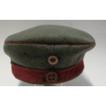 A WW1 style Imperial German Feldmutze soft cap, with Iron Cross badge to red band, bearing
