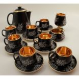 A Prinknash Pottery Gloucester coffee set, in black and gold with white flowers, together with a