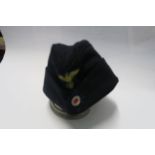 A Third Reich style M38 side hat, in black wool, having appliqued yellow RMBO motif to the front,