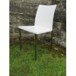 A white Pedrali chair raised on four metal legs