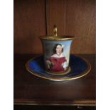 A Viennese style cup and saucer, decorated with a panel of lady, to a blue ground - The cup has a
