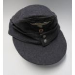 A WW2 German army style M43 field cap, in grey wool, with grey cotton interior, having two metal