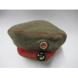 An Imperial German army style beret, in khaki with red headband and piping, with two metal cockade