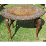 A carved oval mahogany folding table, 33ins x 23.5ins, height 23.5ins