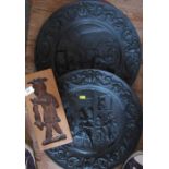 Two pressed metal wall plaques, together with a wood carving of a figure