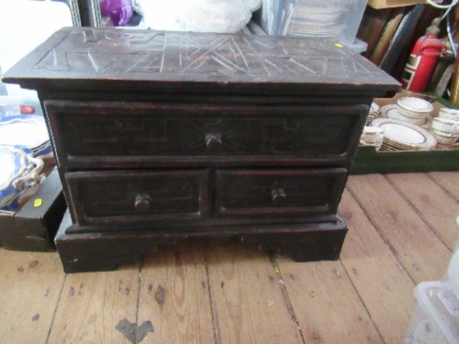 An Eastern low cabinet, with carved decoration, fitted with three drawers, 22ins x 12.5ins, height
