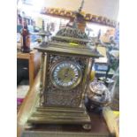 A gilt metal mantle clock, with pierced decoration and enamel numerals