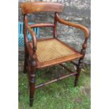 A 19th century mahogany open armchair, with curved top rail, cane seat, on turned front supports