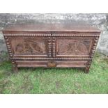 An antique oak mule chest, having rising lid over two carved panels, with moulding, above a