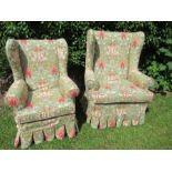 Two similar wing back armchairs, having floral upholstery, raised on short cabriole legs,