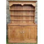 An Antique pine dresser, with close boarded rack back, the base fitted with a pair of cupboard