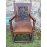 An antique style oak wainscot chair, the back decorated with a relief panel of nativity scene,