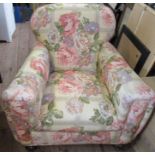 A low upholstered armchair, on front bun feet