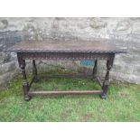 An antique style oak table, raised on turned legs, united by stretchers, 27ins x 56ins x height 29.