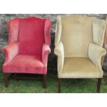 A Georgian design wing back armchair, in red upholstery, raised on square reeded front supports,