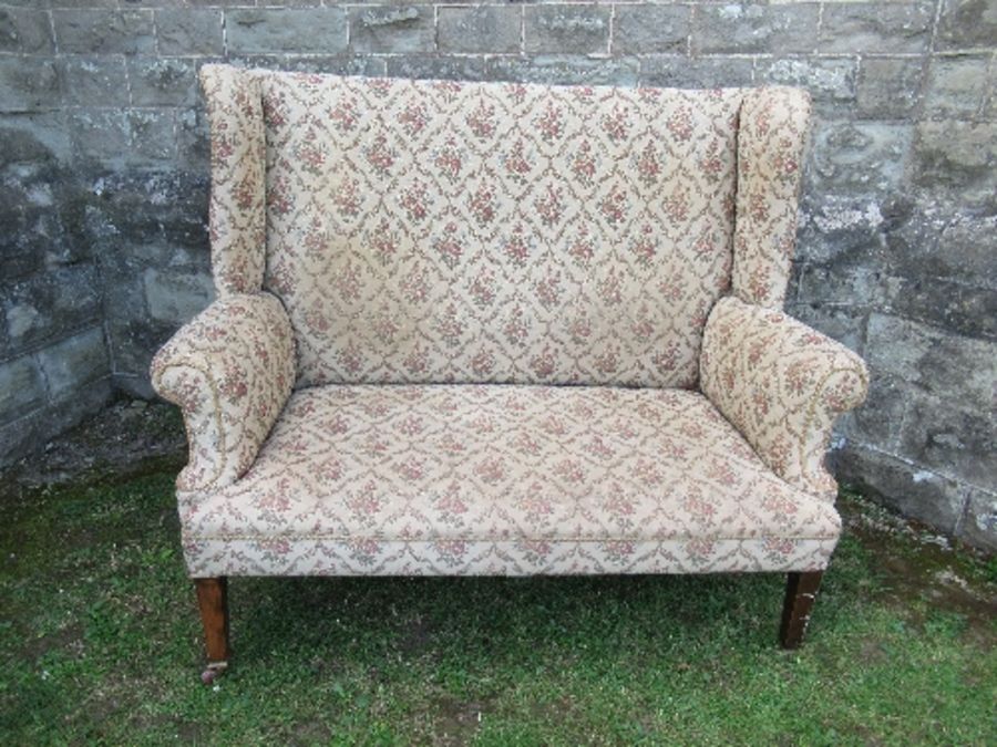 A high backed wing back two seater settee, the floral upholstery, width 53ins x height 47ins