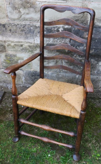 A 19th century Lancashire ladder back open armchair, with rush seat