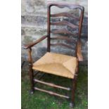 A 19th century Lancashire ladder back open armchair, with rush seat