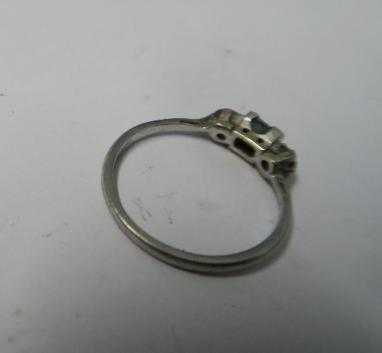 A sapphire and diamond three stone ring, stamped 'Plat', the rectangular cut sapphire flanked either - Image 2 of 2