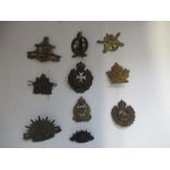 A collection of cap badges from foreign regiments, to include Canada, Australia, New Zealand, Malta,