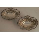 A pair of pierced silver bon bon dishes, of oval form with embossed and pierced decoration, raised