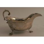 A silver sauceboat, with scroll handle, shaped edge and raised on three pad feet, Birmingham 1932,