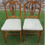 A pair of satinwood bedroom chairs, in the Sheraton revival style, decorated with shells and leaves