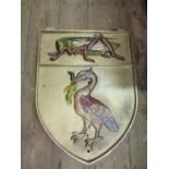 A painted metal heraldic shield, embossed with a grasshopper and bird to both sides, 22ins x 16ins