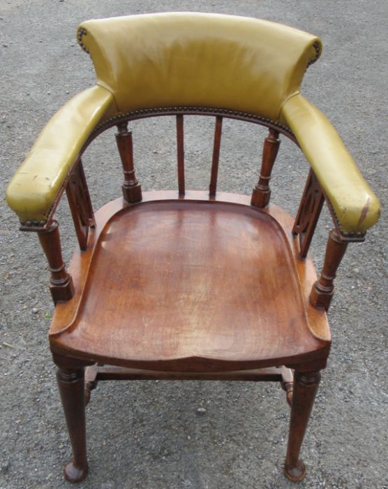 A mahogany desk chair, the curved back with upholstered upper section, raised on turned spindles and