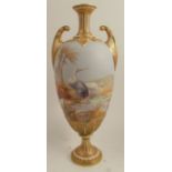 A Royal Worcester vase, decorated in an all around landscape with storks next to an oasis by W