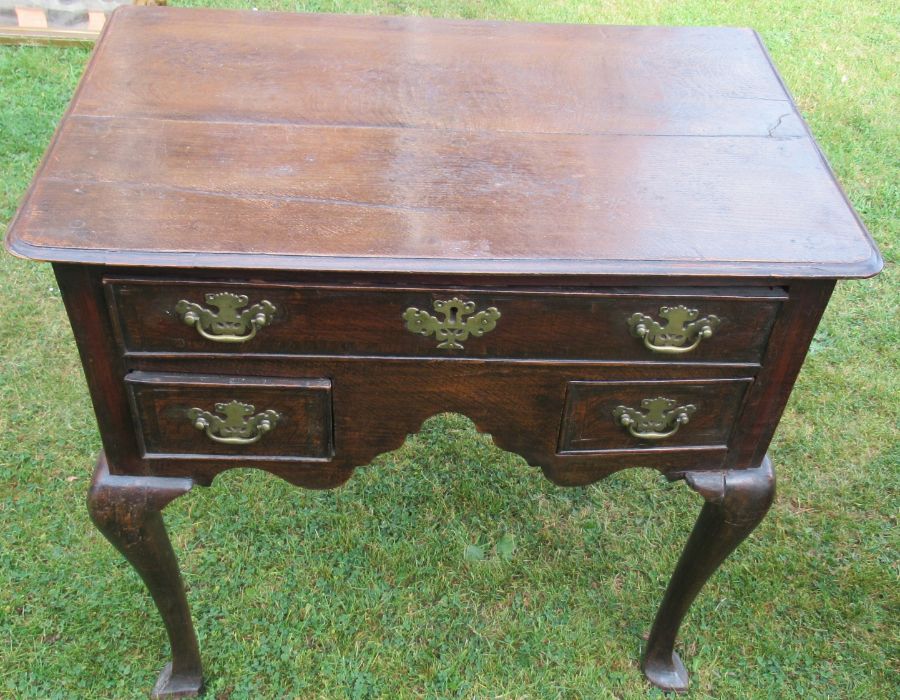 An Antique oak lowboy, fitted one long drawer and two short drawers, raised on cabriole legs and pad