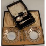 A pair of pierced silver bonbon dishes, together with two pairs of sugar tongs with claw ends,