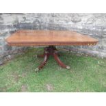 A 19th century mahogany breakfast table, raised on a column with four reeded legs terminating in