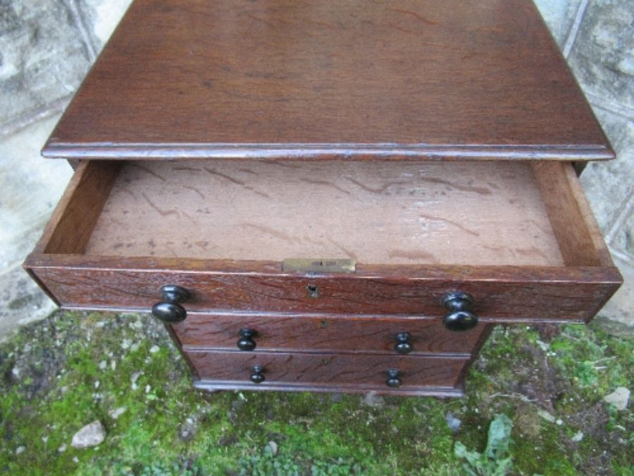 A 19th century late Georgian oak miniature chest of drawers, having five graduated drawers with - Image 2 of 2