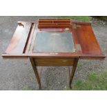 An Edwardian mahogany writing desk, the top fitted with a pair of hinged flaps, opening to reveal