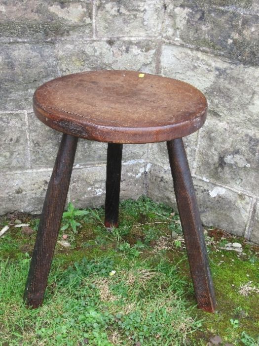 An Antique cricket style table, with circular top and raised on three legs, diameter 16ins, height