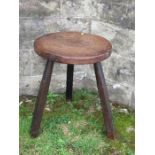 An Antique cricket style table, with circular top and raised on three legs, diameter 16ins, height