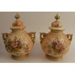 Two similar Royal Worcester blush ivory covered vases, with pierced covers, the body decorated