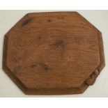 A Robert Mouseman Thompson oak octagonal bread board, carved with a mouse, 12ins x 10ins