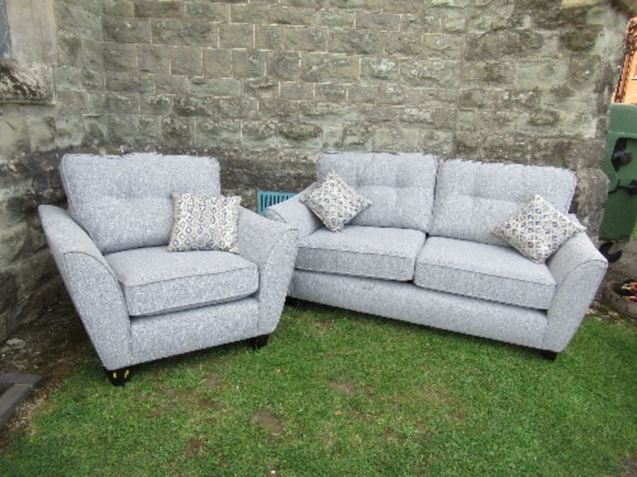 A two seat sofa, together with a single armchair, in grey upholstery, with fire labels