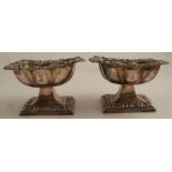 A pair of silver pedestal salts, of rectangular form, with scroll and leaf edge, engraved with a