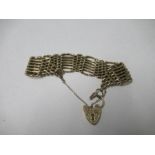 A yellow metal gate link bracelet, with a gold heart shaped lock, 26g gross