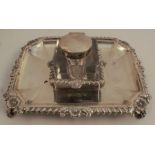 A silver desk stand, of rectangular form, set with a glass inkwell, the stand with flower and