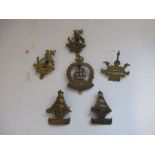 A collection of cap badges from the Royal Navy, to include Drake, Hood (2), Nelson (2) and Anson